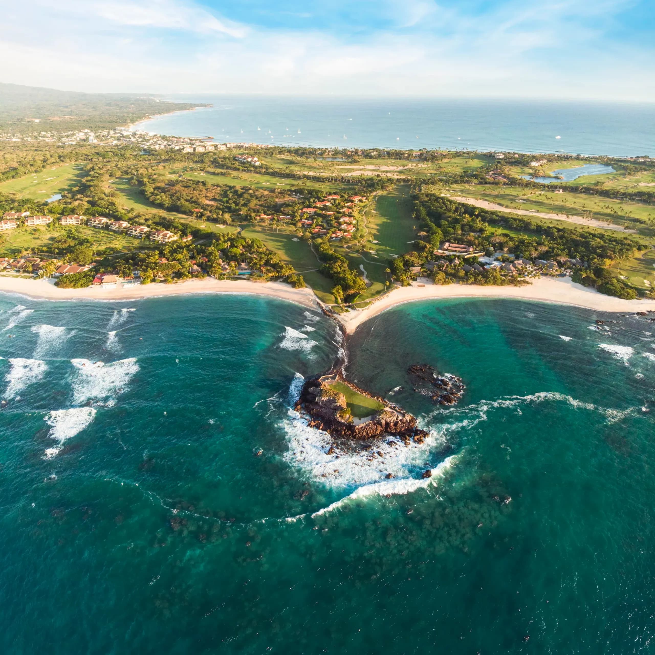 Vista aérea panorámica de la península del campo de golf Pacifico en Punta Mita, mostrando el icónico green isla natural, Cola de la Ballena, rodeado por el Océano Pacífico.